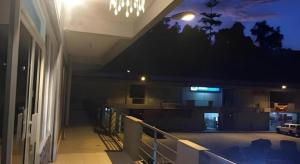 a balcony of a building at night with a chandelier at The Second Room in Ranau