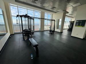 a gym with two tread machines in a room with windows at Spacious 3BR Seaview Duplex Perfect for Families in Ajman 