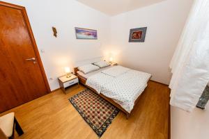 Habitación pequeña con cama y puerta en Apartment Eva, en Klimno