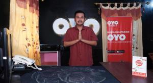 a man standing in front of a table with his hands in front at Hotel O Udan Mas Guesthouse& Gallery in Mendut