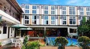 a large building with a swimming pool in front of it at AEROSTOP HOTEL & RESTAURANT in Kutkot