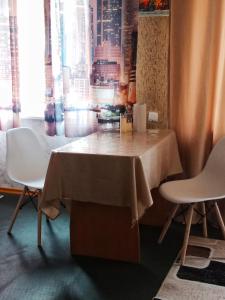 a table in a room with two chairs and a window at 2х комнатная квартира в центре in Ustʼ-Kamenogorsk