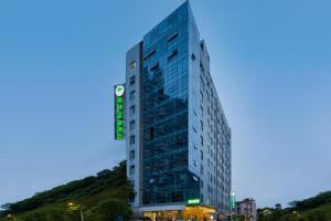 a tall building with a green sign on it at GreenTree Inn JinDeZhen People Square Taoxichuan Wenchuang Street in Jingdezhen