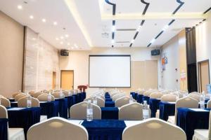 a conference room with chairs and a white screen at Lavande Hotel Foshan Shunde Shunlian Plaza Jinlong Metro Station in Shunde