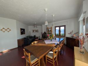 a kitchen and dining room with a wooden table and chairs at Casa Stocke - Relax e natura in Contrà Zocchi in Asiago