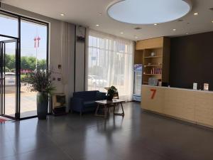 - un hall de bureau avec un canapé bleu et une table dans l'établissement 7 Days Premium Nanchang Xiaolan Industrial Park Bogang Metro Station, à Lianxi