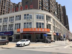 une voiture blanche garée devant un immeuble dans l'établissement 7 Days Premium Nanchang Xiaolan Industrial Park Bogang Metro Station, à Lianxi