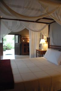 a bedroom with a large bed with a canopy at Terra Dos Goitis - Chalés - Pipa in Pipa