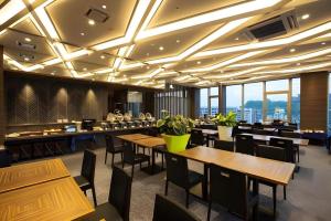 a restaurant with wooden tables and chairs and windows at Hotel Gran Cerezo Kagoshima in Kagoshima