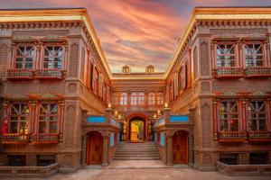 a building with a stairway leading into a building with a sunset at Wusong Guyi Western Regions Designer Courtyard in Yining