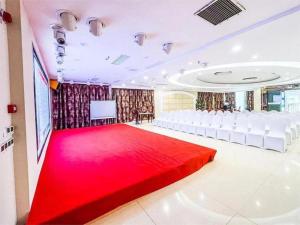 une grande pièce avec un tapis rouge et des chaises blanches dans l'établissement 7 Days Premium Chongqing Fuling Binjiang Avenue Branch, à Fuling