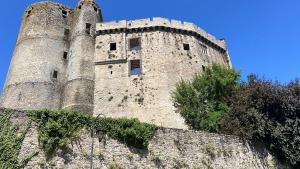 a tall brick building with towers on top of a wall at Hotel Rivella - The Originals Boutique in Clisson +15 photos