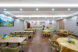 a dining room with tables and chairs and a cafeteria at GreenTree Inn Linxi International Convention Center Express Hotel in Wangjiaqiao