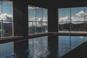 Camp John HayにあるThe Plaza Lodge Baguioの窓付きの水のプールのある建物