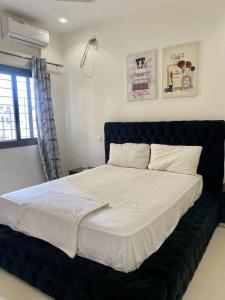 a large bed with a black headboard in a bedroom at Studio equipped to your liking in Dakar +5 photos