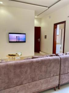 a living room with a couch and a tv on a wall at Studio equipped to your liking in Dakar