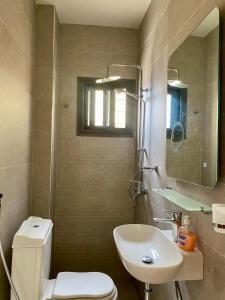 a bathroom with a toilet and a sink and a mirror at Studio equipped to your liking in Dakar