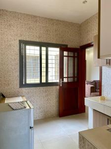 a kitchen with a red door and a window at Studio equipped to your liking in Dakar