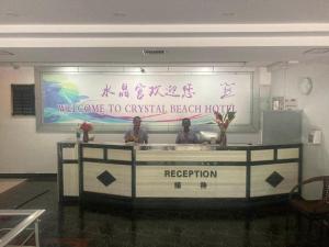 ポートビラにあるCrystal Palace Hotelの建物内の受付カウンターに立っている二人