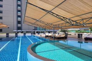 a large swimming pool with a large umbrella in a building at ONE Residence in Ban Lam Rua Taek