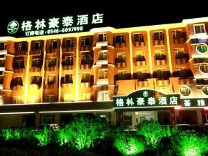 a large building with writing on it at night at GreenTree Inn Dongying Xisi Road Huachuang Building in Kenli
