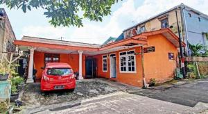 a red car parked in front of a house at OYO 92759 Penginapan Piji Kembar in Tawangmangu