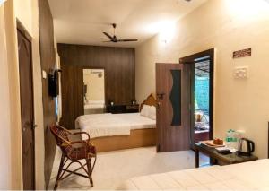 a bedroom with a bed and a desk and a chair at The Whistling Pine Woods in Varagampadi +34 photos