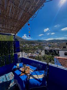een balkon met een tafel en stoelen en uitzicht bij DAR AMRANi in Chefchaouene