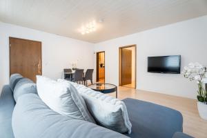 uma sala de estar com um sofá azul e uma TV em Evin's Apartment em Kehl am Rhein