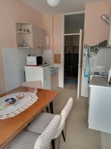 a small kitchen with a wooden table and chairs at ,,Vruć Vetar,, in Majdanpek