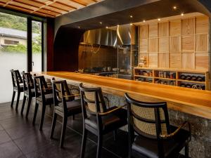 a bar with a row of chairs in a kitchen at Hakone Hibarino in Hakone