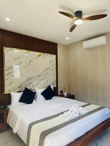 a bedroom with a large bed with a ceiling fan at Real Hostel in Koh Rong