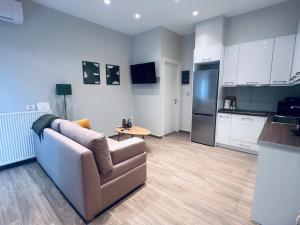 a living room with a couch and a kitchen at Hodos Luxury APT 2 near ATH-Airport in Markopoulo