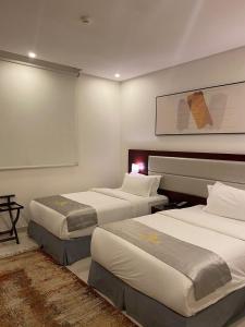 a hotel room with two beds at منازل التوت للشقق المخدومة الوسام in Taif