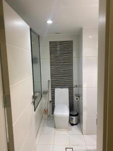 a bathroom with a toilet and a glass shower at منازل التوت للشقق المخدومة الوسام in Taif +21 photos