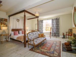 テンベリーにあるHilltop Houseのベッドルーム(天蓋付きベッド1台、椅子付)