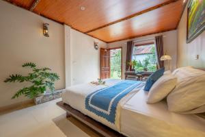 a bedroom with a large bed with a wooden ceiling at Tam Coc Luxury Homestay in Ninh Binh