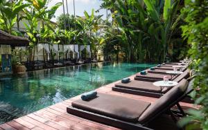 uma fileira de espreguiçadeiras ao lado de uma piscina em Residence Indochine d'Angkor em Siem Reap