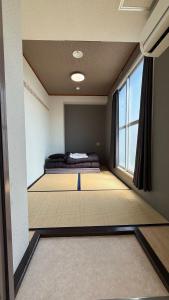 a room with two beds and a window at Namba Ambers Hostel 6606 in Osaka