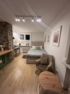 a bedroom with a bed and a couch and a chair at Apartament The Space 2 in Drawsko Pomorskie