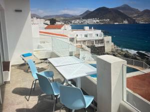 サン・ホセにあるBeachfront apartamento in san joséのテーブルと椅子と海のあるバルコニー