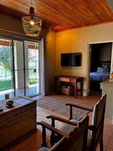 KeimoesにあるDagbreek Cottagesのテレビとテーブルと椅子のあるリビングルーム