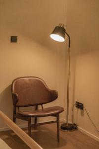 a chair sitting next to a lamp in a room at Dali Mountain and Lake View Hotel in Dali Shuanglang