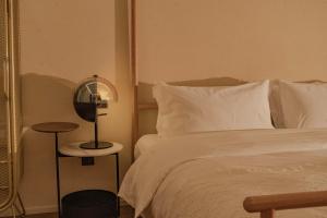 a bedroom with a white bed and a side table at Dali Mountain and Lake View Hotel in Dali Shuanglang +229 photos