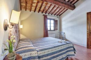 a bedroom with a bed with a blue and white blanket at Agriturismo Il Selvino in Terricciola