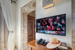 a room with a television and a hat on a table at The Charming Lonno Lodge Watamu in Watamu