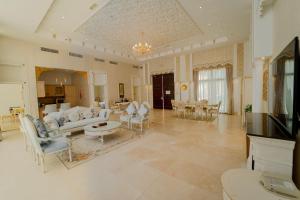 a large living room with white furniture and a table at Western Hotel - Madinat Zayed in Madīnat Zāyid