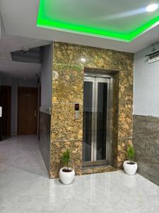 zwei Topfpflanzen auf der Seite eines Gebäudes in der Unterkunft Hotel G7 in Indore