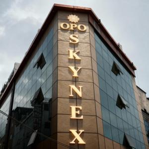 uma placa na lateral de um prédio em OPO Essential SKYNEX em Nova Deli