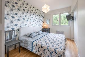 1 dormitorio con 1 cama con pared de color azul y blanco en Appartement 4 Pièces, 3 Chambres, en Les Sables-dʼOlonne